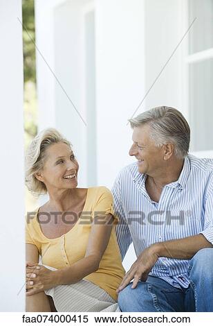 Mature couple sitting together outdoors View Large Photo Image Stock Photography - Mature couple sitting together outdoors. Fotosearch