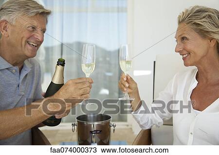 Mature couple toasting with champagne View Large Photo Image Stock Image - Mature couple toasting with champagne. Fotosearch