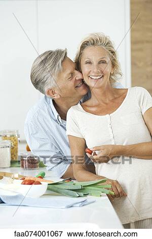 Mature couple together in kitchen, man nuzzling woman, portrait View Large Photo Image Stock Photo - Mature couple together in kitchen, man nuzzling woman, portrait. Fotosearch