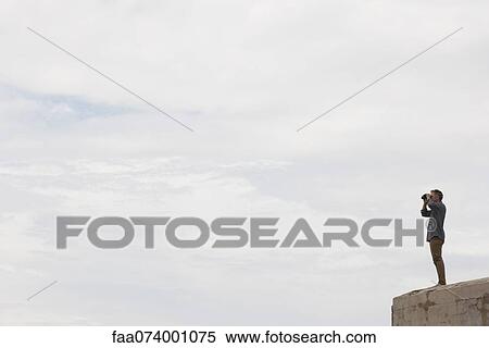 Mature man looking at view through binoculars View Large Photo Image Stock Photography - Mature man looking at view through binoculars. Fotosearch