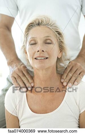 Stock Photo - Mature woman having her shoulders massaged. Fotosearch