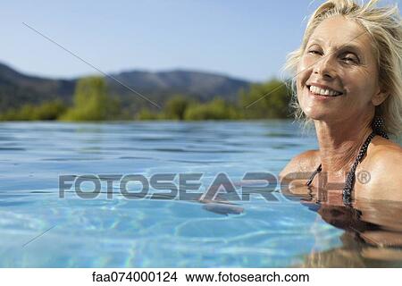 Mature woman relaxing in pool, portrait View Large Photo Image Picture - Mature woman relaxing in pool, portrait. Fotosearch