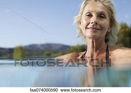 Mature woman relaxing in pool, portrait View Large Photo Image Stock Image - Mature woman relaxing in pool, portrait. Fotosearch