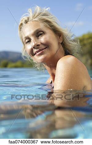 Stock Photo - Mature woman relaxing in pool, portrait. Fotosearch