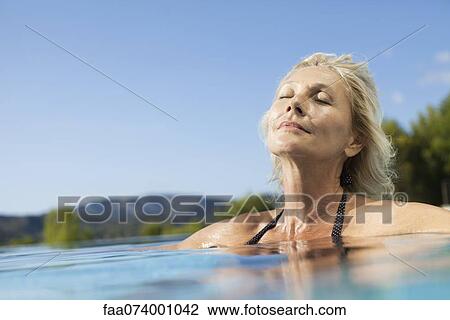 Mature woman relaxing in pool with eyes closed View Large Photo Image Stock Image - Mature woman relaxing in pool with eyes closed. Fotosearch