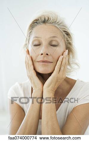 Mature woman touching her face, eyes closed, portrait View Large Photo Image Picture - Mature woman touching her face, eyes closed, portrait. Fotosearch