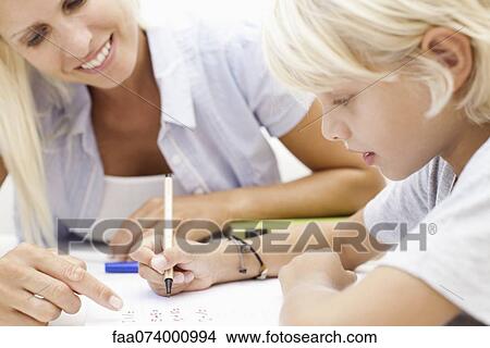 Mother helping son with homework View Large Photo Image Picture - Mother helping son with homework. Fotosearch