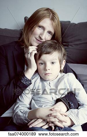 Stock Photo - Mother holding son on her lap, portrait. Fotosearch