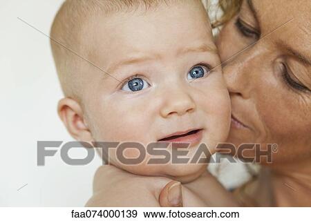 Stock Photo - Mother kissing baby's cheek. Fotosearch