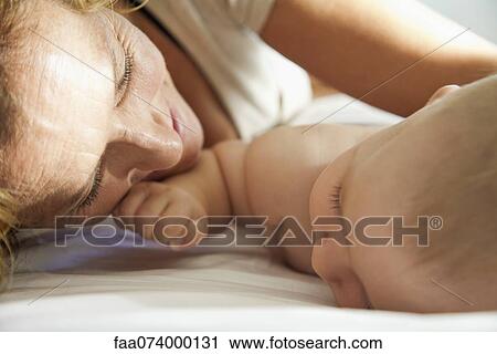 Mother lying down beside baby View Large Photo Image Stock Image - Mother lying down beside baby. Fotosearch