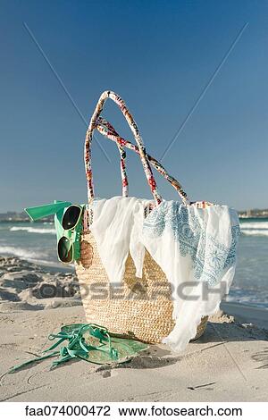 Stock Image - Packed beach bag on beach. Fotosearch