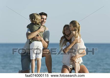 Parents embracing children at the beach View Large Photo Image Stock Photography - Parents embracing children at the beach. Fotosearch