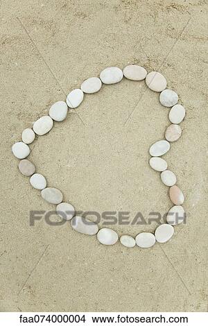 Pebbles arranged in heart shape on sand View Large Photo Image Picture - Pebbles arranged in heart shape on sand. Fotosearch