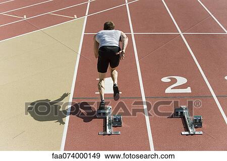 Stock Photo - Runner at starting line, rear view. Fotosearch