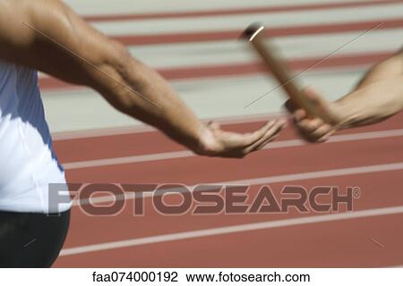 Runners exchanging baton in relay race, cropped View Large Photo Image Stock Image - Runners exchanging baton in relay race, cropped. Fotosearch