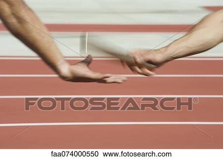 Runners exchanging baton in relay race, cropped View Large Photo Image Stock Image - Runners exchanging baton in relay race, cropped. Fotosearch