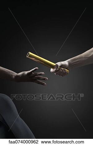 Stock Image - Runners passing baton, cropped. Fotosearch