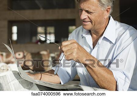 Stock Photograph - Senior man reading newspaper. Fotosearch