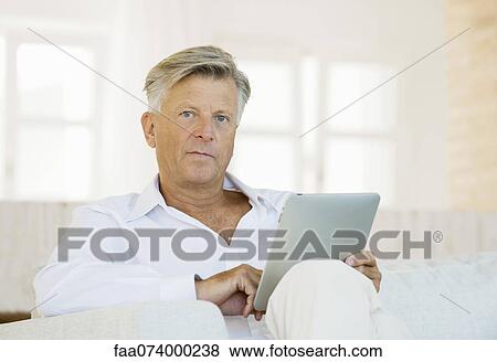 Stock Photo - Senior man using digital tablet. Fotosearch