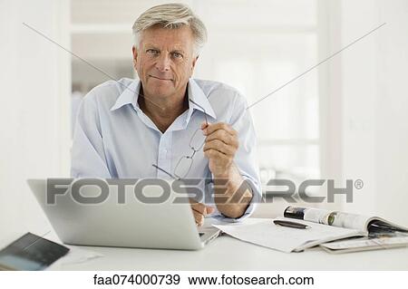 Senior man using laptop computer at home View Large Photo Image Stock Photo - Senior man using laptop computer at home. Fotosearch
