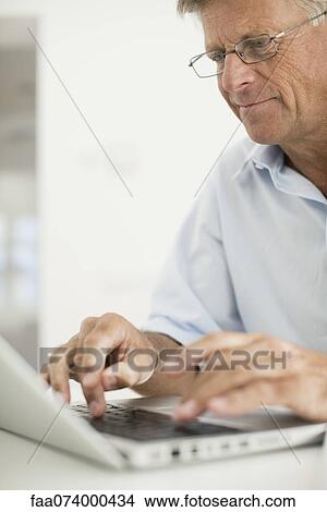 Senior man using laptop computer View Large Photo Image Picture - Senior man using laptop computer. Fotosearch