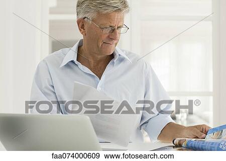 Senior man working on laptop computer at home View Large Photo Image Stock Photo - Senior man working on laptop computer at home. Fotosearch