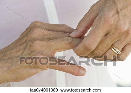 Senior woman rubbing knuckles, cropped View Large Photo Image Stock Image - Senior woman rubbing knuckles, cropped. Fotosearch