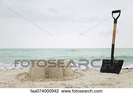 Shovel stuck in sand beside sand castle at the beach View Large Photo Image Stock Image - Shovel stuck in sand beside sand castle at the beach. Fotosearch