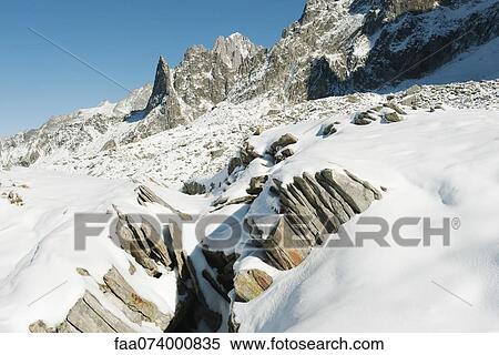 Stock Photography - Snow-covered rocks and mountain range. Fotosearch