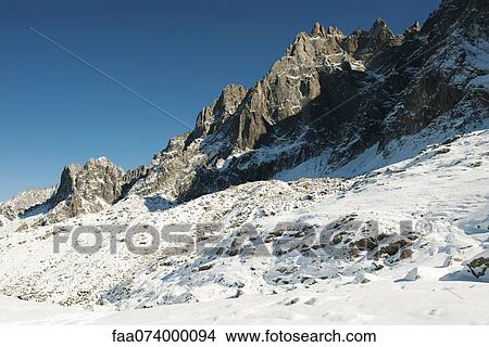 Picture - Snowy mountain peaks against clear sky. Fotosearch