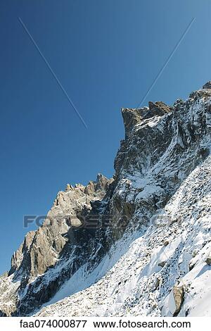 Stock Photo - Steep mountains covered in snow. Fotosearch