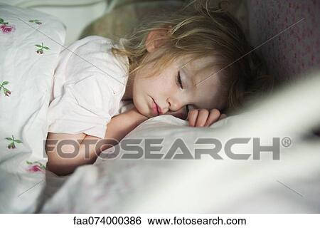 Stock Photograph - Toddler sleeping in bed. Fotosearch
