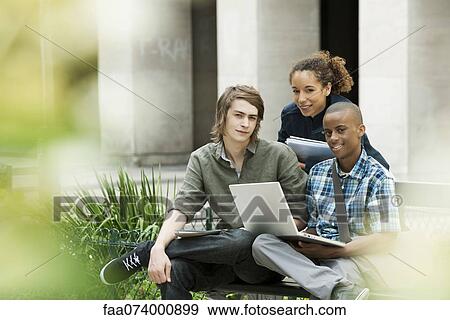 University students on campus with laptop computer View Large Photo Image Stock Photo - University students on campus with laptop computer. Fotosearch