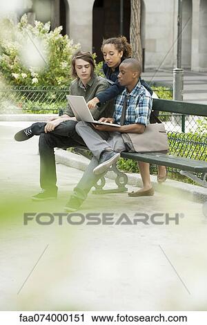 Stock Image - University students studying on campus with laptop computer. Fotosearch