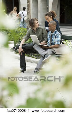 University students studying on campus with laptop computer View Large Photo Image Stock Image - University students studying on campus with laptop computer. Fotosearch