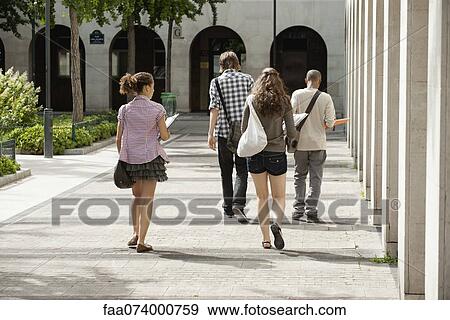 Stock Photo - University students walking on campus, rear view. Fotosearch