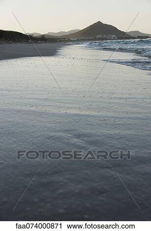 Stock Image - Waves lapping onto beach. Fotosearch