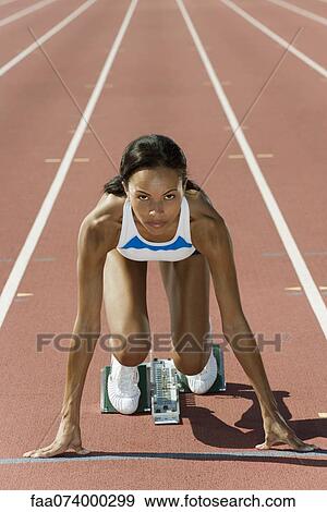 Woman crouched in starting position on running track View Large Photo Image Stock Photo - Woman crouched in starting position on running track. Fotosearch