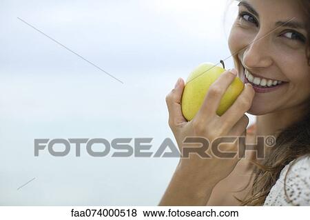 Woman eating apple, portrait View Large Photo Image Stock Photo - Woman eating apple, portrait. Fotosearch
