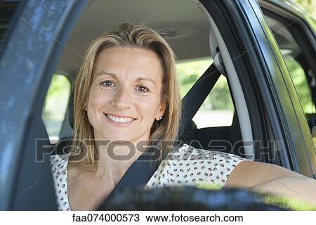 Woman in car, smiling out window, portrait View Large Photo Image Stock Image - Woman in car, smiling out window, portrait. Fotosearch