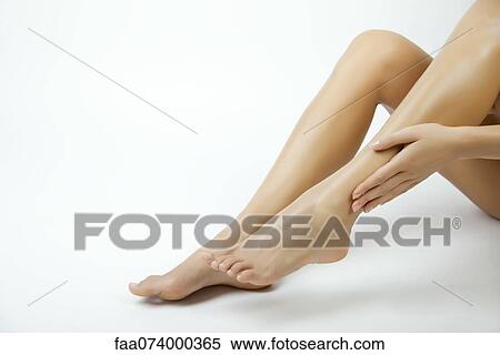 Woman moisturizing legs, cropped View Large Photo Image Stock Photography - Woman moisturizing legs, cropped. Fotosearch