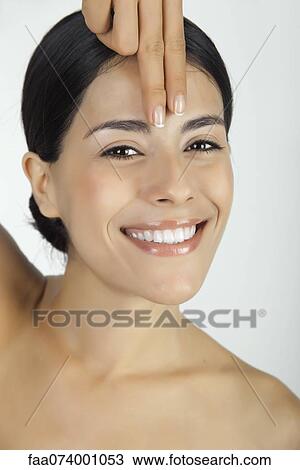 Woman placing fingers on forehead, portrait View Large Photo Image Stock Image - Woman placing fingers on forehead, portrait. Fotosearch