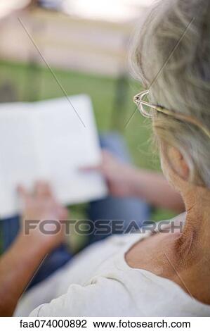 Stock Image - Woman reading, over the shoulder view. Fotosearch