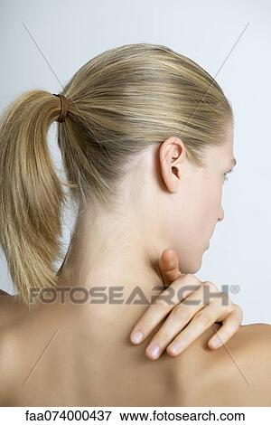 Stock Photo - Woman rubbing neck, rear view. Fotosearch