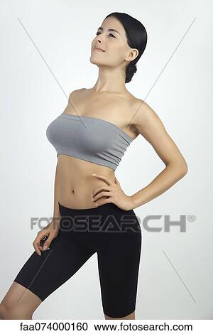 Stock Image - Woman standing with hand on hip, portrait. Fotosearch