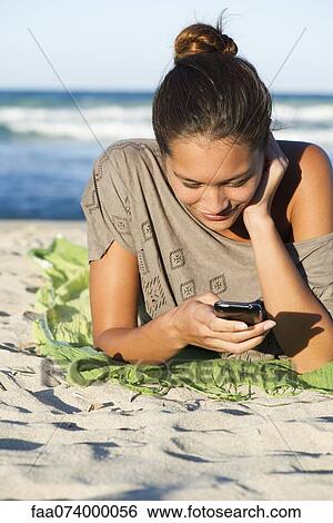 Woman text messaging on beach View Large Photo Image Stock Photograph - Woman text messaging on beach. Fotosearch
