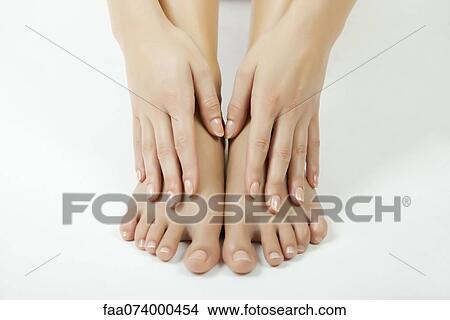 Picture - Woman touching her bare feet, cropped. Fotosearch