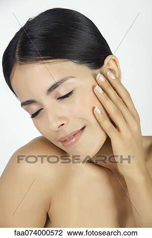 Woman touching her face, eyes closed View Large Photo Image Stock Image - Woman touching her face, eyes closed. Fotosearch