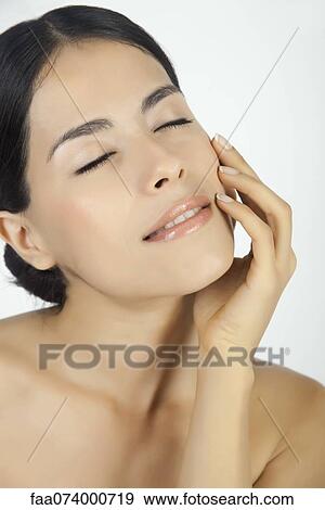Stock Photo - Woman touching her face, eyes closed. Fotosearch