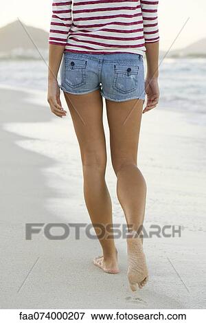 Woman walking on beach, rear view, cropped View Large Photo Image Stock Photo - Woman walking on beach, rear view, cropped. Fotosearch